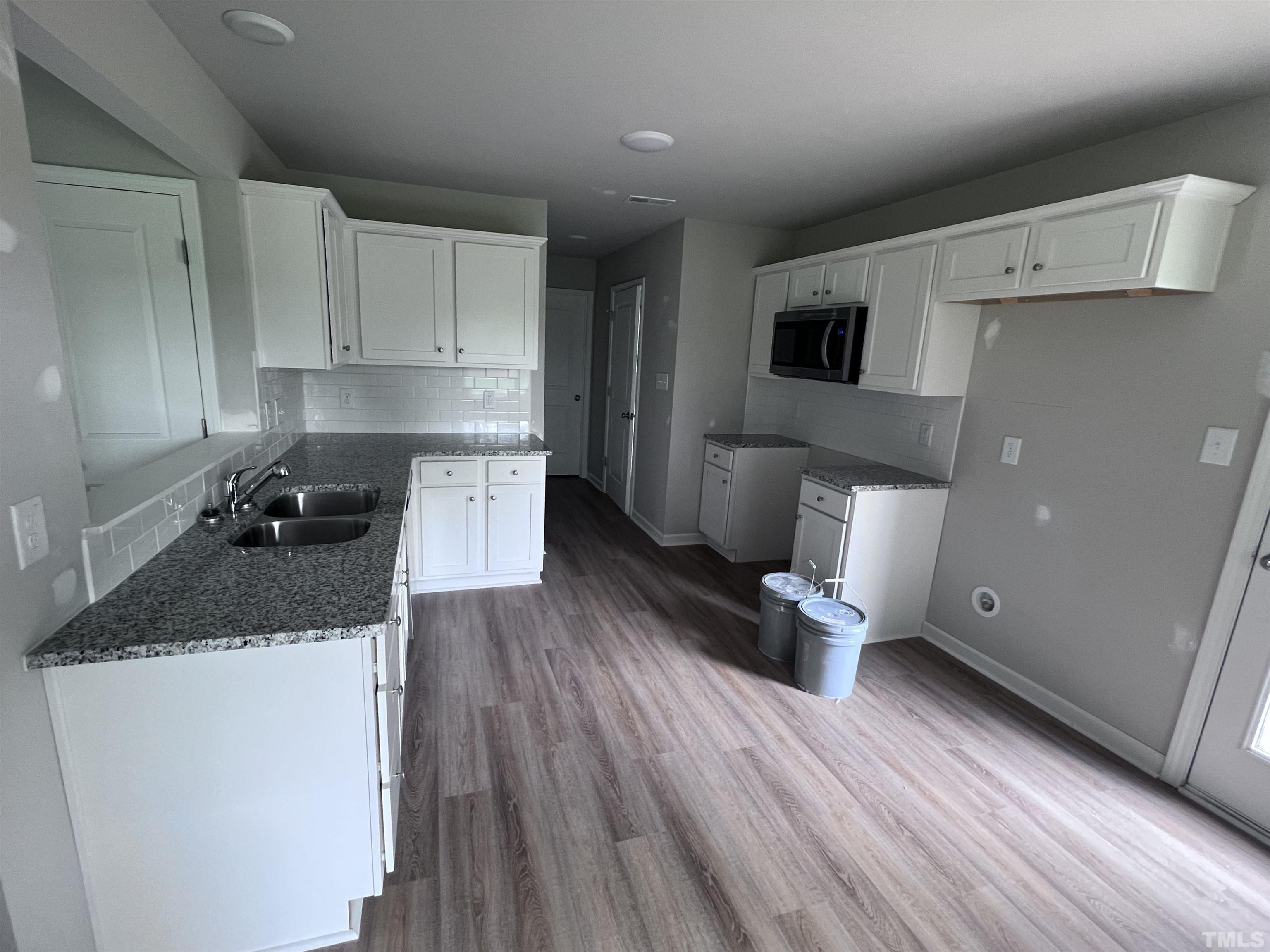 390 Roberts Road Willow Spring, NC 27592 - Photo 7 of 18 a kitchen with granite countertop a sink dishwasher stove and cabinets
