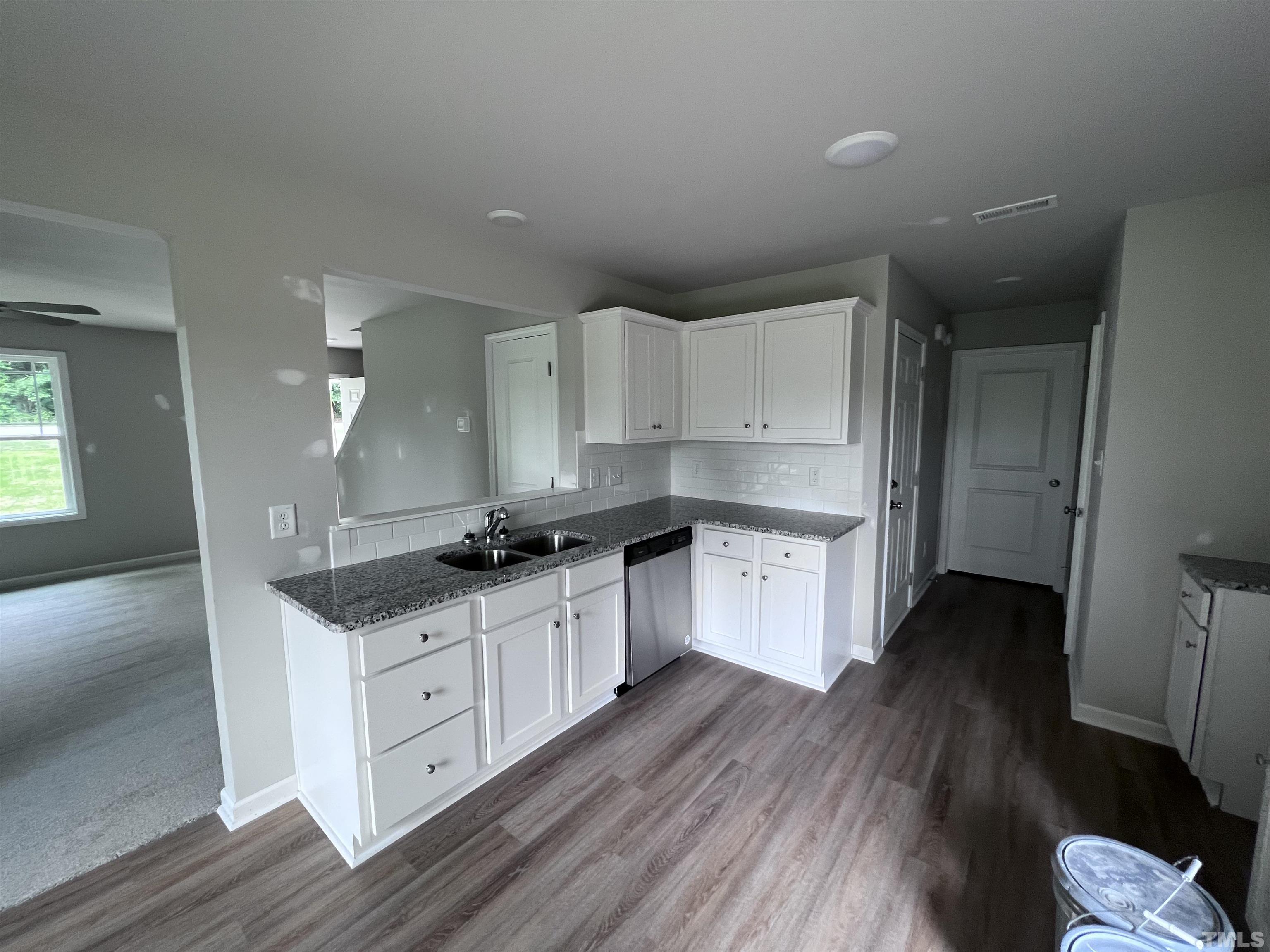 390 Roberts Road Willow Spring, NC 27592 - Photo 8 of 18 a kitchen with granite countertop a sink and a stove top oven