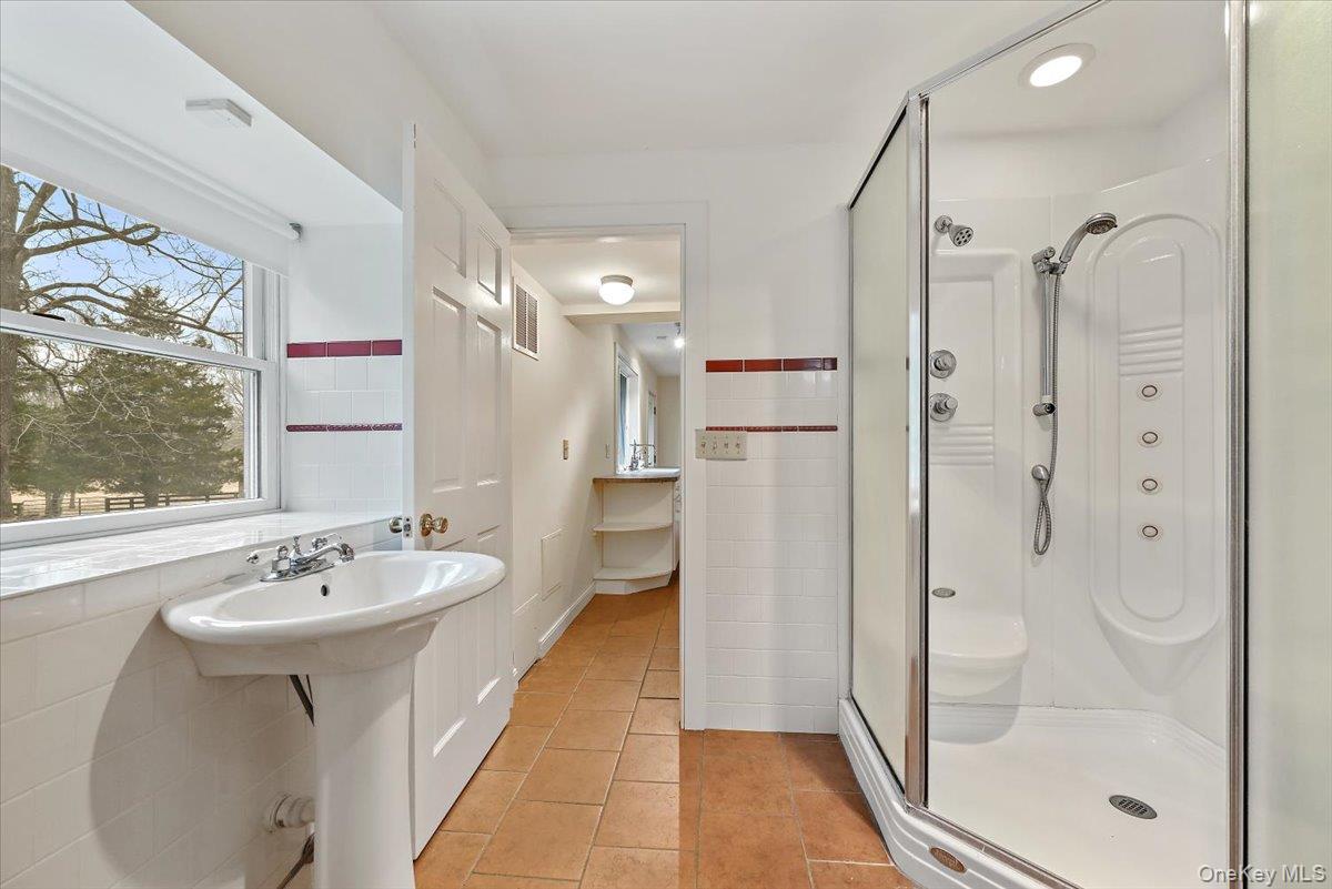 948 Craigville Road Chester, NY 10918 - Photo 19 of 42 a bathroom with a sink a mirror and a glass door shower