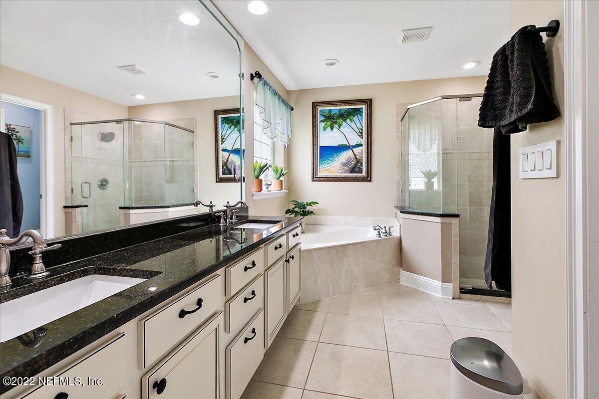 86003 Maple Leaf Place Yulee, FL 32097 - Photo 11 of 27 a spacious bathroom with a granite countertop sink a toilet a mirror and vanity
