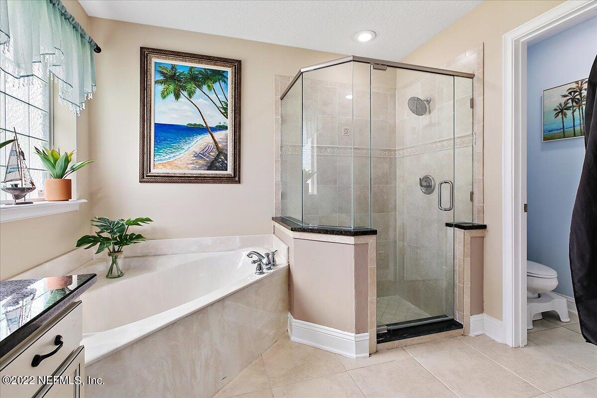 86003 Maple Leaf Place Yulee, FL 32097 - Photo 12 of 27 a bathroom with a tub a potted plant and a shower