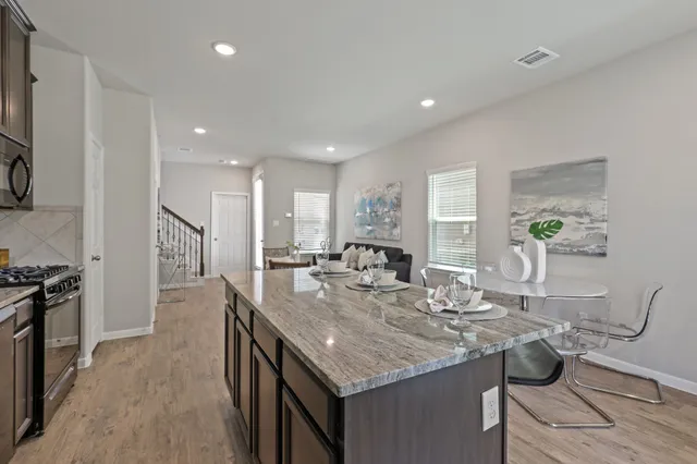 a kitchen with granite countertop kitchen island stainless steel appliances a sink and cabinets
