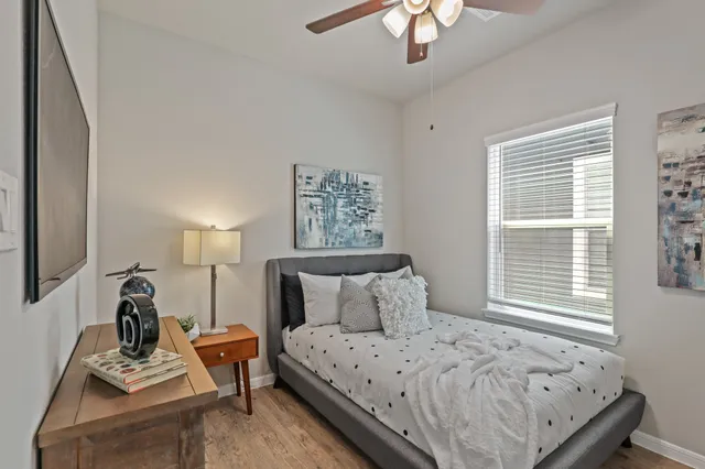 a bedroom with a bed a chandelier and a window