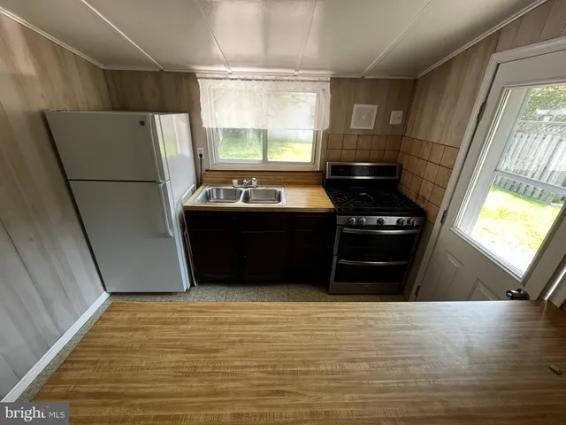 a view of kitchen with refrigerator and wooden floor