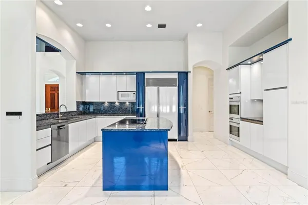 a kitchen with granite countertop a sink and a refrigerator
