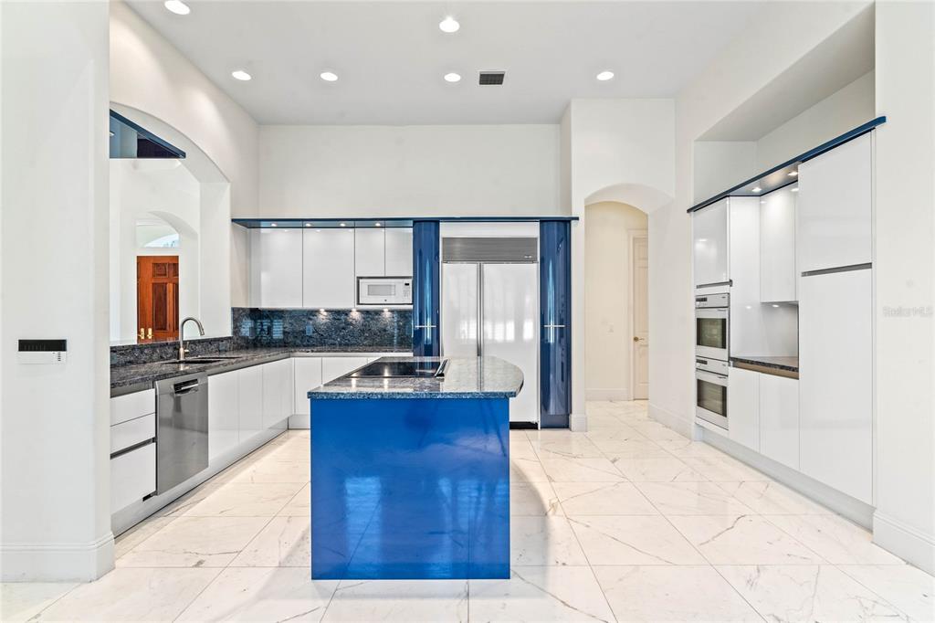 9701 Lake Isleworth Court Windermere, FL 34786 - Photo 25 of 31 a large white kitchen with stainless steel appliances kitchen island granite countertop a refrigerator and stove top oven