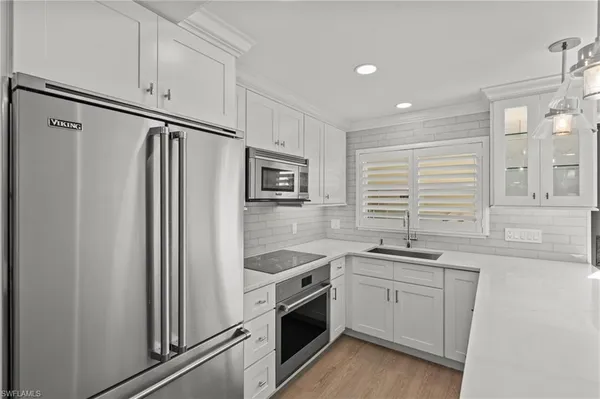 a kitchen with stainless steel appliances white cabinets and a sink