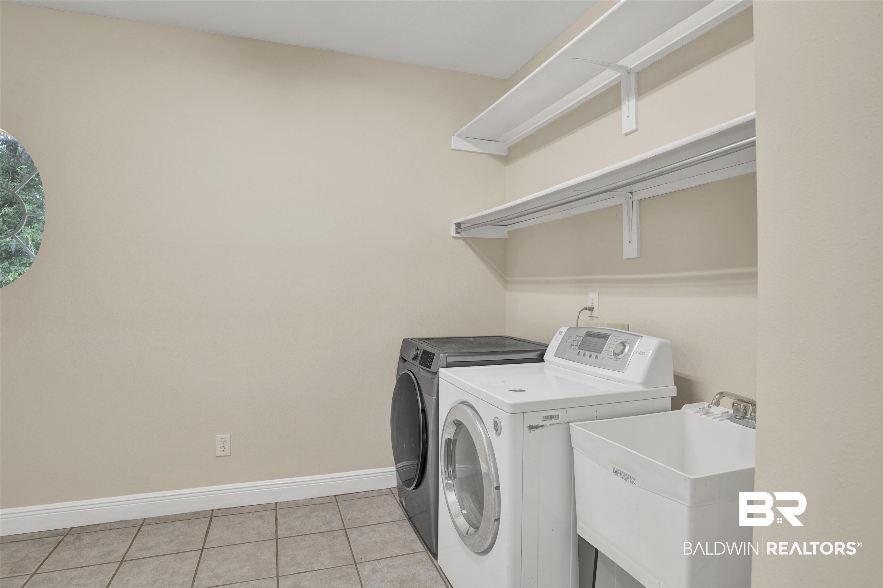 8847 Dawes Lake Road South Mobile, AL 36619 - Photo 13 of 47 Dedicated utility room featuring neutral wall tones, tile flooring, and a round window