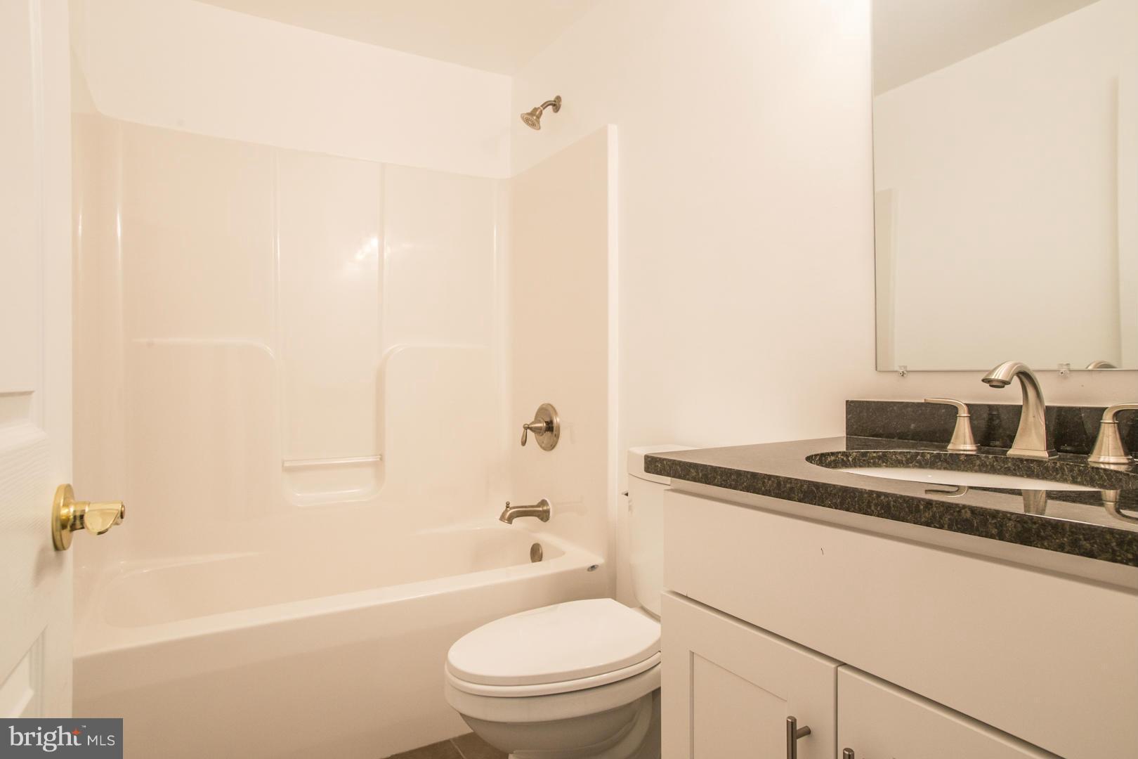 1995 Sixes Road Prince Frederick, MD 20678 - Photo 21 of 30 a bathroom with a granite countertop sink a toilet and bathtub