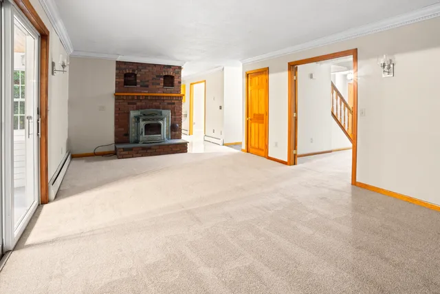 a view of an empty room with a fireplace and a window