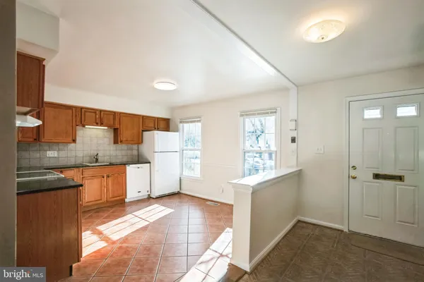 a large kitchen with a stove a sink dishwasher and a refrigerator