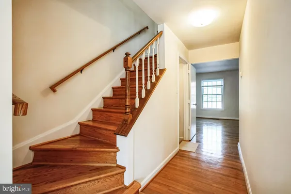 a view of staircase with wooden floor and a rug