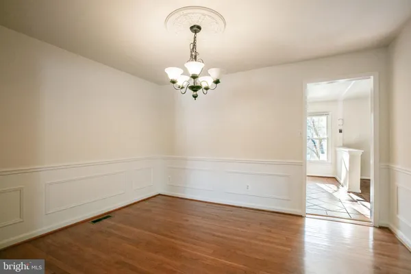 a view of a room with wooden floor and a ceiling fan