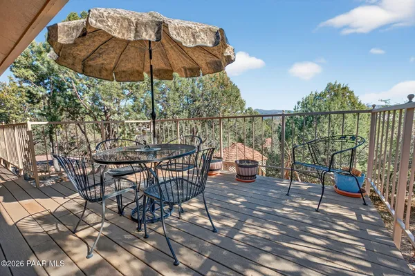 a bedroom with a bed a mirror on dresser and a wooden floor