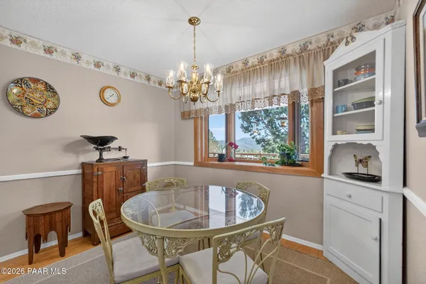 a view of a patio with table and chairs under an umbrella with wooden floor