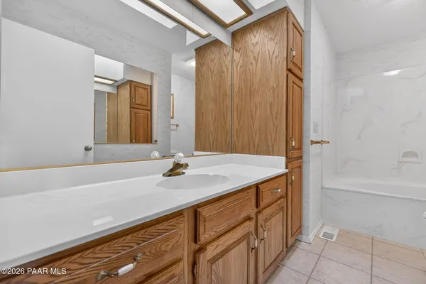 a view of a yard with plants and a large tree