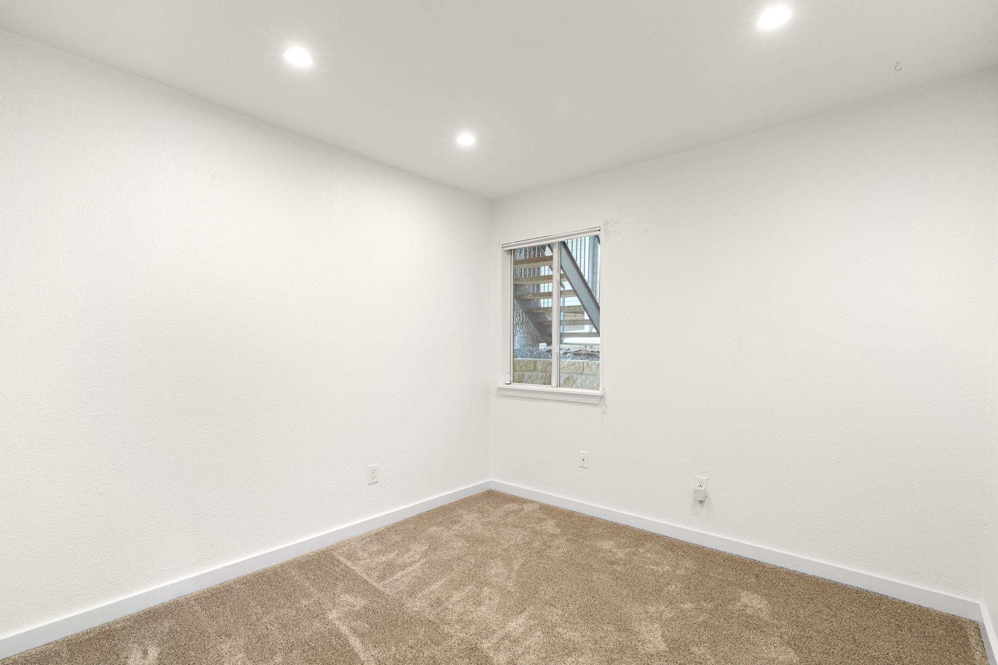 3601 Menchaca Road, Unit 110 Austin, TX 78704 - Photo 21 of 37 Recessed lighting illuminates this versatile room with plush carpeting and an exterior view.