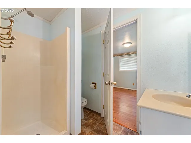 a view of an empty room with wooden floor