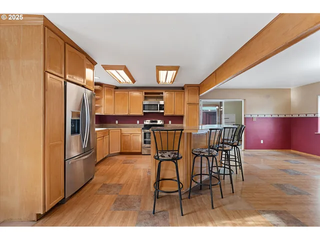 a kitchen with stainless steel appliances kitchen island granite countertop a stove a sink and a microwave