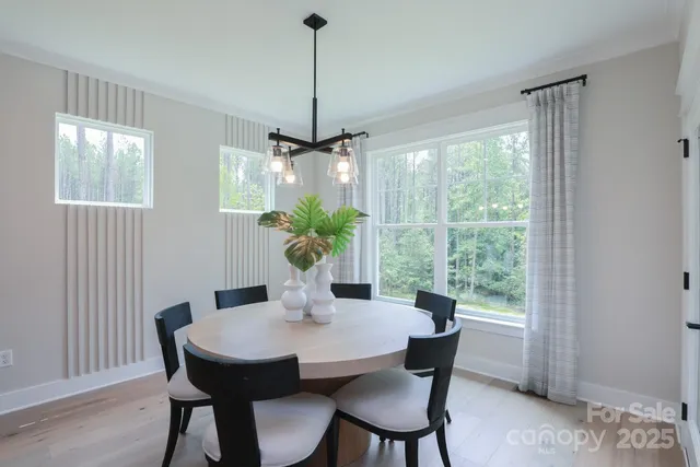 a dining room with furniture window and wooden floor