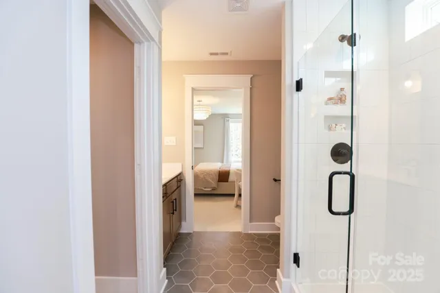 a bedroom with a bed chandelier and a window