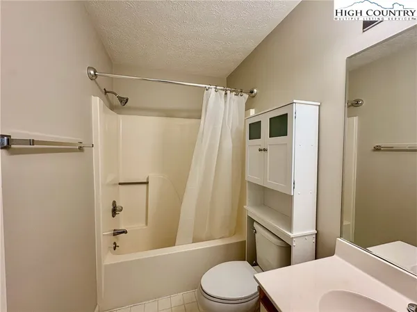 a white toilet sitting next to a bathroom sink and a shower