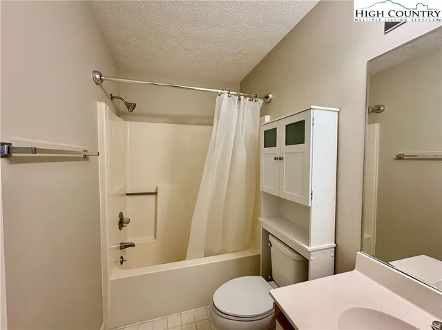 a white toilet sitting next to a bathroom sink and a shower
