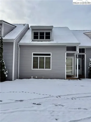 a view of a house with a yard and potted plants