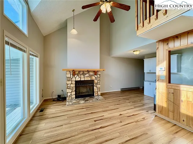 a view of empty room with a fireplace and wooden floor