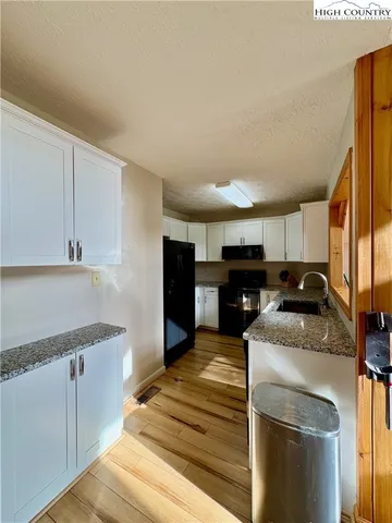 a kitchen with granite countertop a sink and a stove top oven