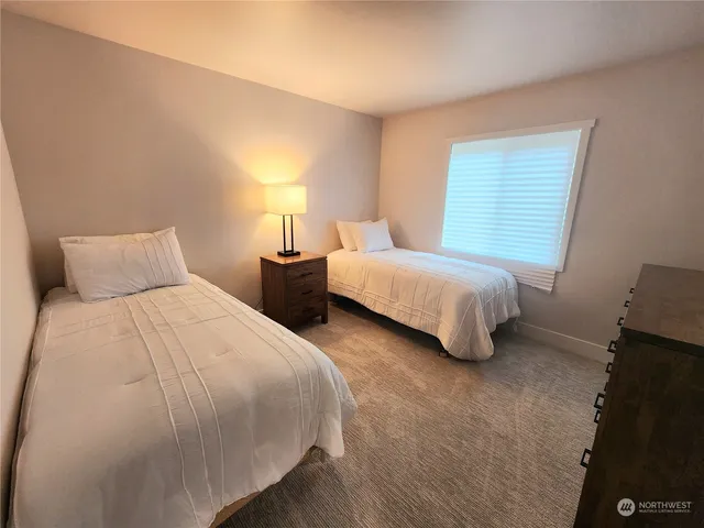 a bedroom with two bed and a window