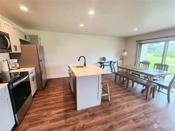 a dining room with furniture a floor to ceiling window and wooden floor