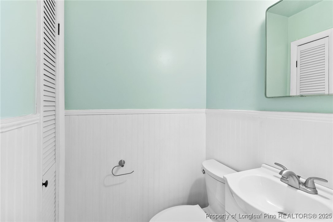 1512 Crescent Drive Spring Lake, NC 28390 - Photo 23 of 36 a bathroom with a sink a toilet and a mirror