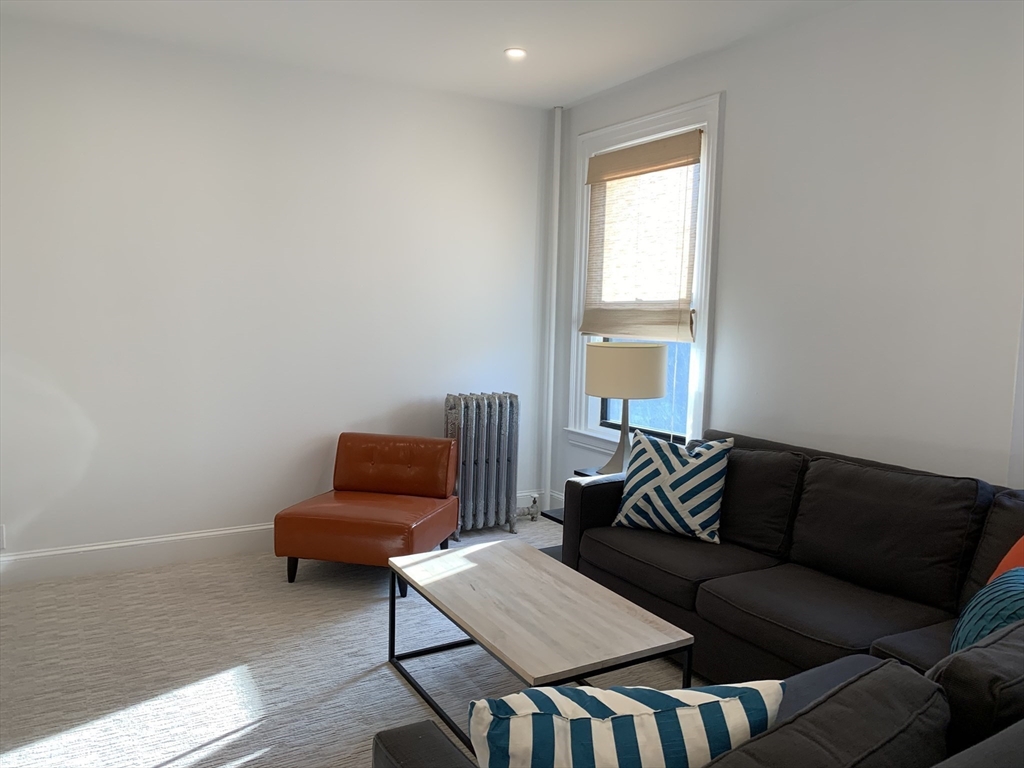 1064 Beacon Street, Unit 9 Brookline, MA 02446 - Photo 11 of 19 a living room with furniture and a window