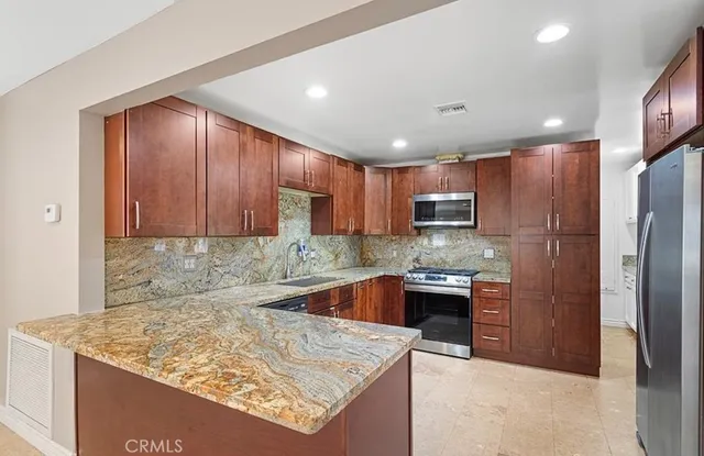 a kitchen with stainless steel appliances granite countertop a sink stove and refrigerator