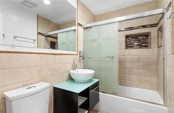 a bathroom with a shower a sink and a toilet