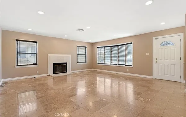 an empty room with windows and fireplace