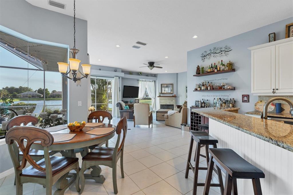 9910 Laurel Valley Ave Circle Bradenton, FL 34202 - Photo 15 of 37 a view of a dining room and livingroom with furniture wooden floor a rug a painting and a chandelier