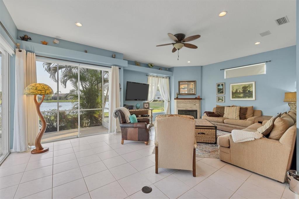 9910 Laurel Valley Ave Circle Bradenton, FL 34202 - Photo 16 of 37 a living room with furniture a flat screen tv and a floor to ceiling window