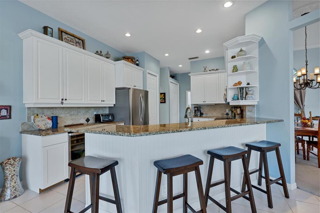 9910 Laurel Valley Ave Circle Bradenton, FL 34202 - Photo 19 of 37 a kitchen with stainless steel appliances granite countertop a table chairs sink and cabinets