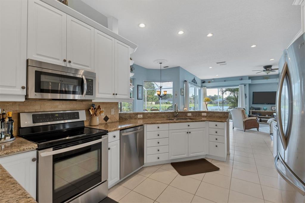 9910 Laurel Valley Ave Circle Bradenton, FL 34202 - Photo 20 of 37 a kitchen with stainless steel appliances a stove sink microwave and cabinets