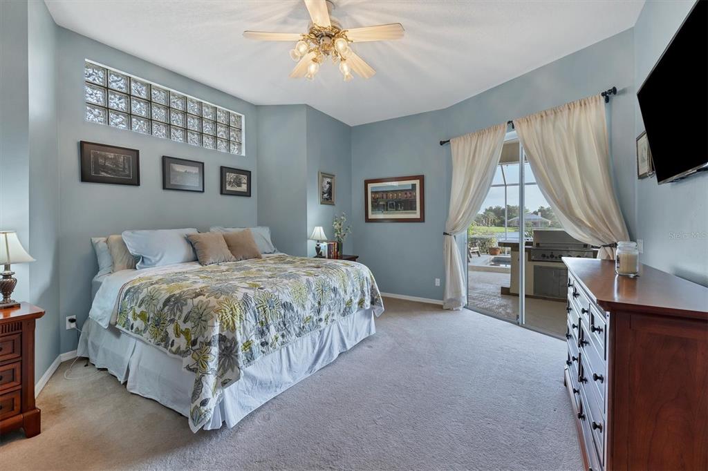 9910 Laurel Valley Ave Circle Bradenton, FL 34202 - Photo 22 of 37 a spacious bedroom with a bed and a chandelier