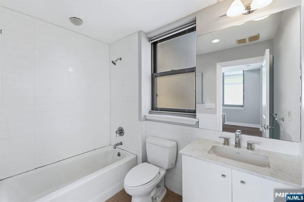8125 River Road, Unit 4E North Bergen, NJ 07047 - Photo 16 of 35 a bathroom with a toilet a sink and a bathtub