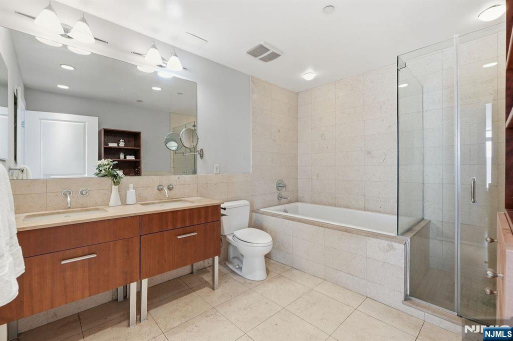 8125 River Road, Unit 4E North Bergen, NJ 07047 - Photo 24 of 35 a bathroom with a toilet sink and mirror