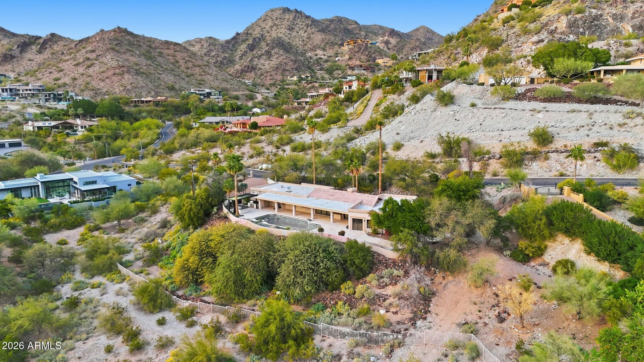 an aerial view of house with yard and mountain view in back