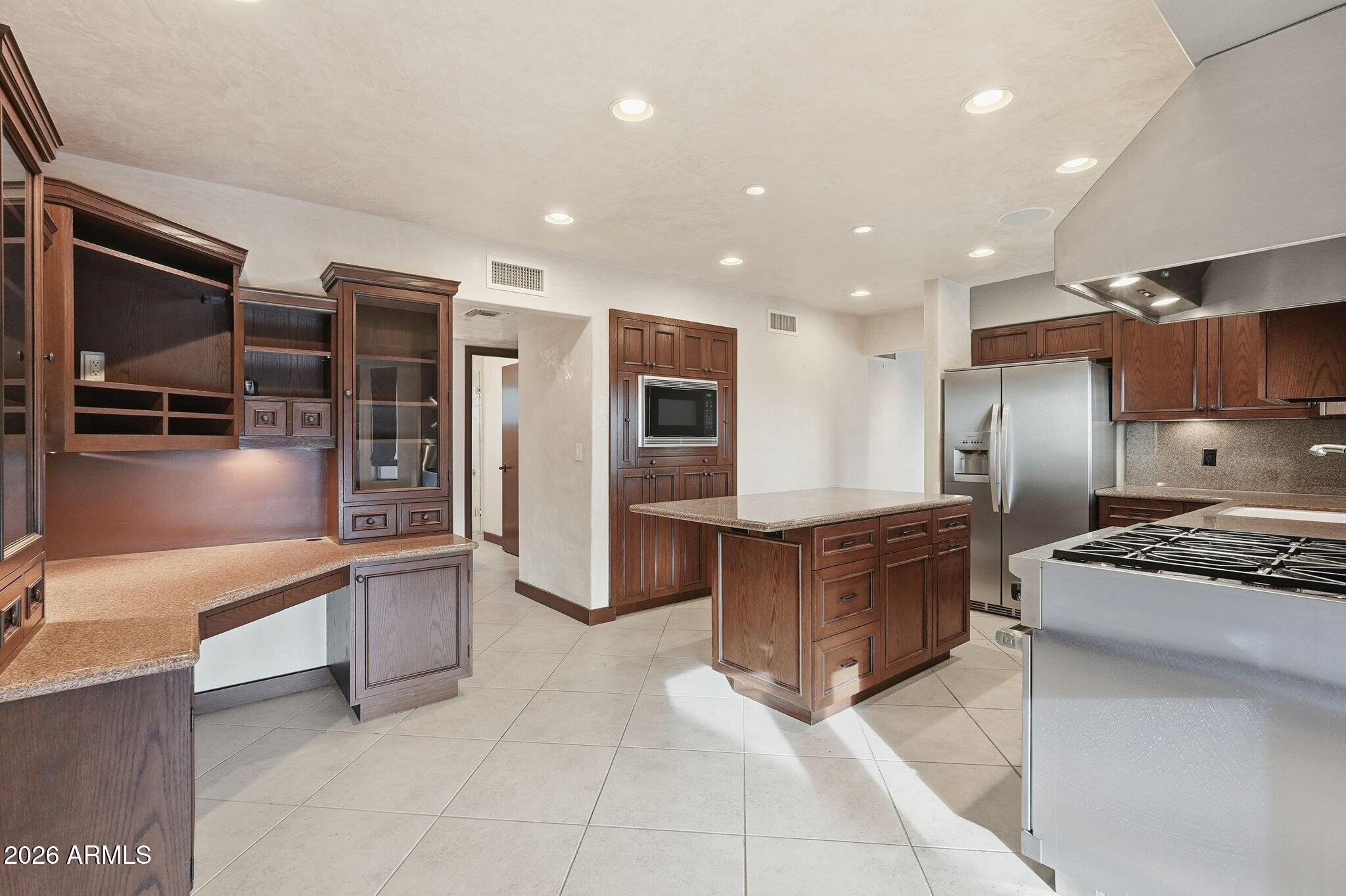 4021 East Lamar Road Paradise Valley, AZ 85253 - Photo 22 of 48 a kitchen with stainless steel appliances granite countertop a refrigerator and a stove top oven