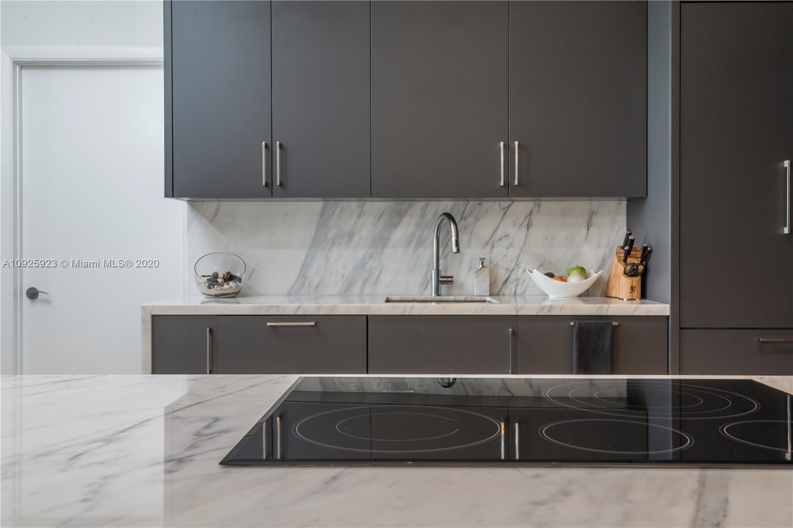400 Alton Road, Unit 1007 Miami Beach, FL 33139 - Photo 3 of 13 a kitchen with a sink and cabinets