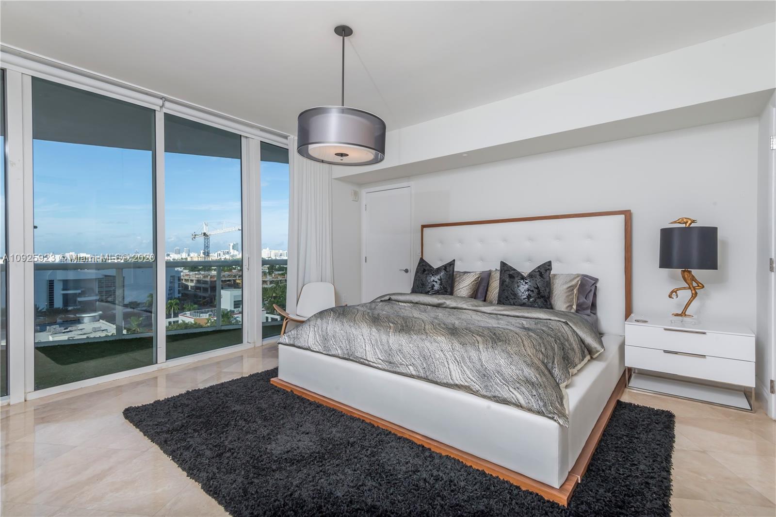 400 Alton Road, Unit 1007 Miami Beach, FL 33139 - Photo 7 of 13 a bedroom with a large bed and a chandelier