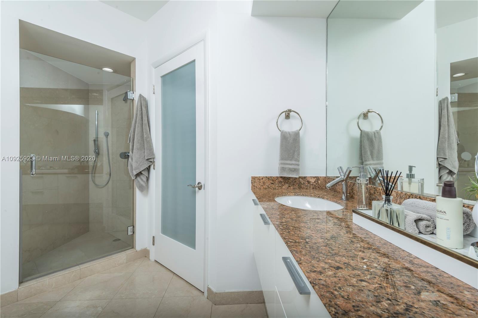 400 Alton Road, Unit 1007 Miami Beach, FL 33139 - Photo 8 of 13 a bathroom with a granite countertop sink and a mirror