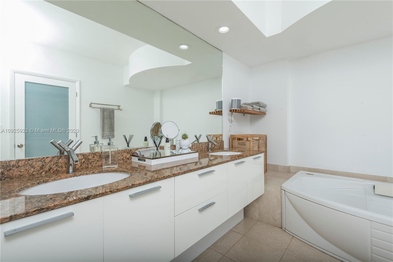 400 Alton Road, Unit 1007 Miami Beach, FL 33139 - Photo 9 of 13 a bathroom with a granite countertop sink a toilet and a mirror